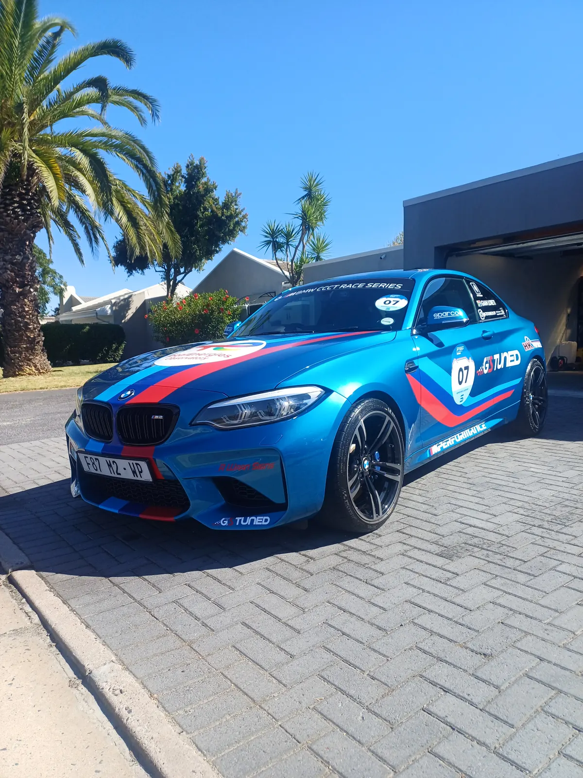 BMW M2 race car detailed on a driveway